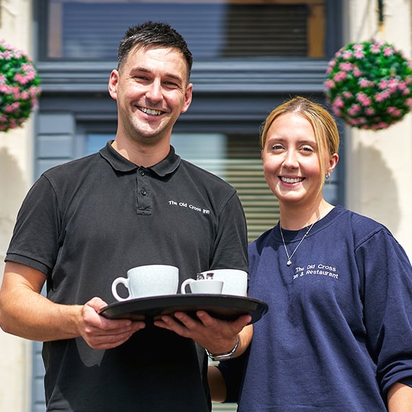 Two servers holding tray of coffees