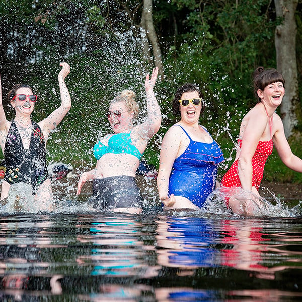 Wild swimmers splashing around in a river