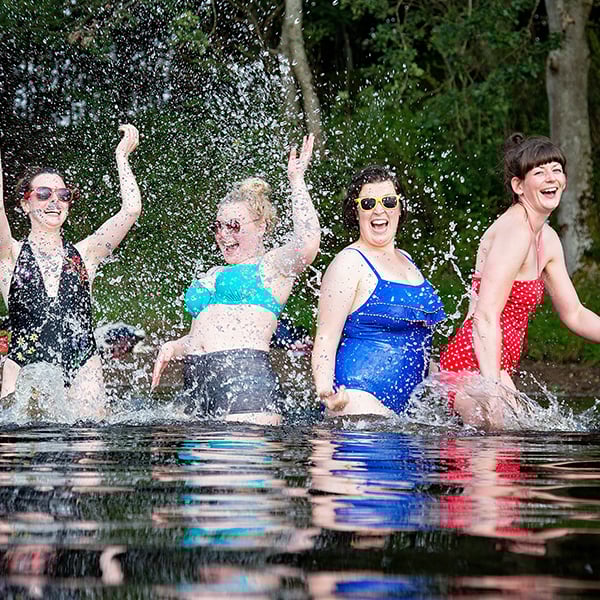 Wild swimmers splashing around in a river