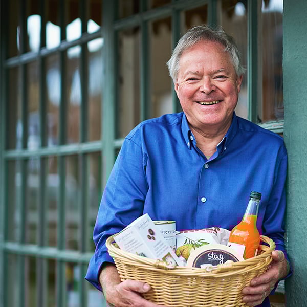man in blue shirt holding hamper of local produce