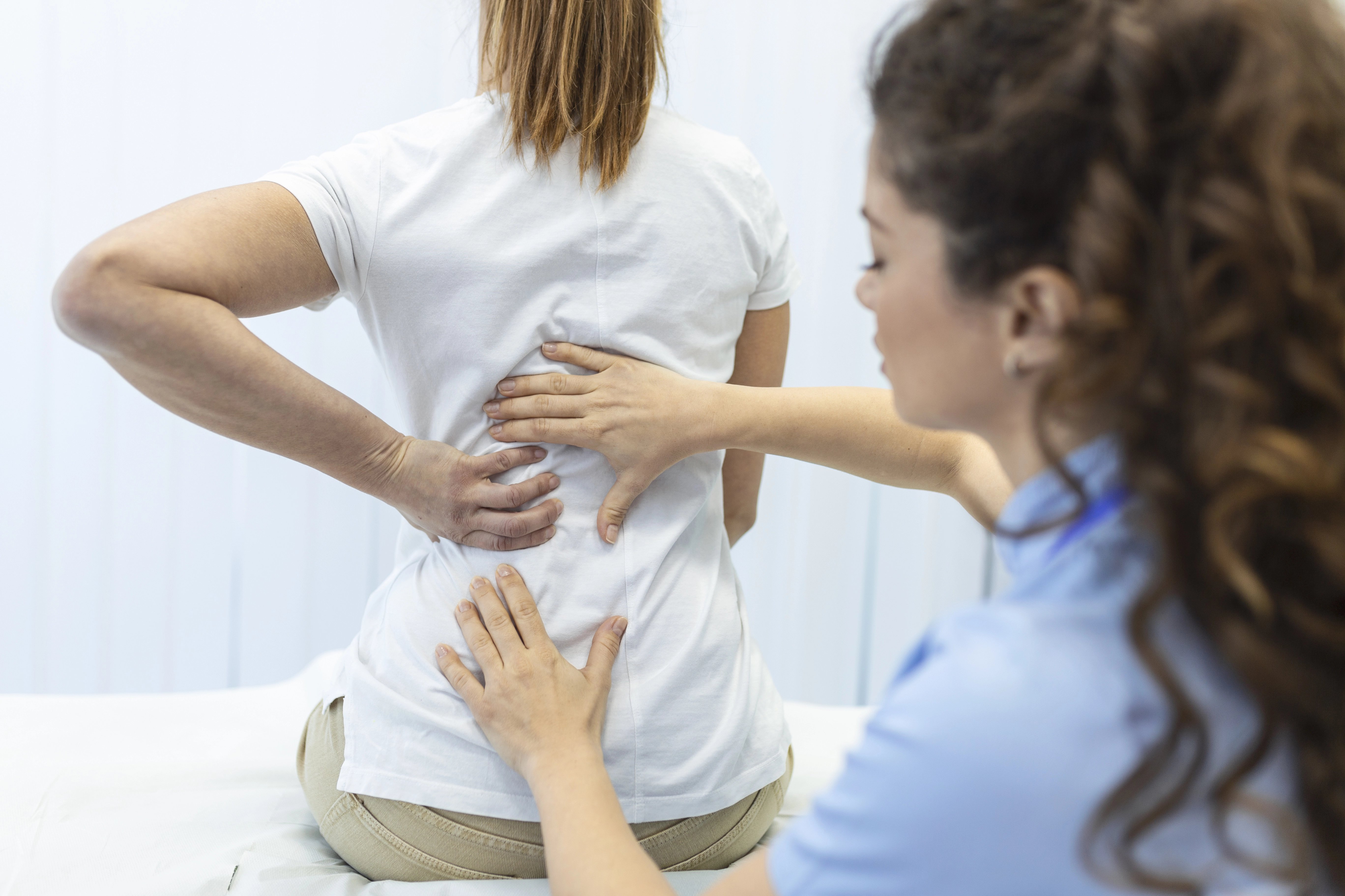physiotherapist-doing-healing-treatment-womans-back-back-pain-patient-treatment-medical-doctor-massage-therapistoffice-syndrome