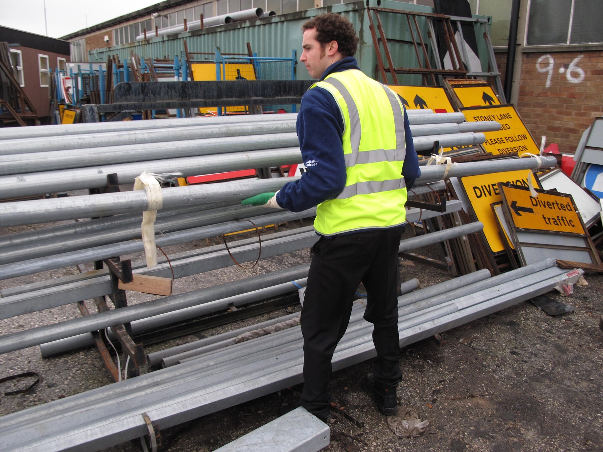 Man lifting scaffold poles at work