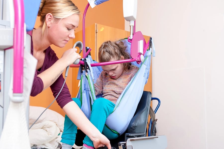 Carer supporting less-abled child in a buggy