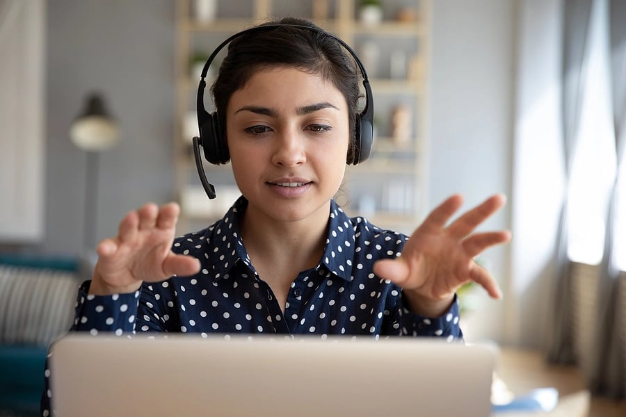 Female DSE user at her workstation wearing a headset