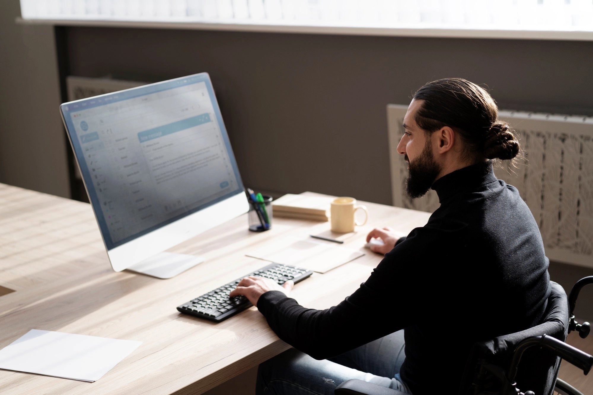 Man sitting at tidy, organised computer desk