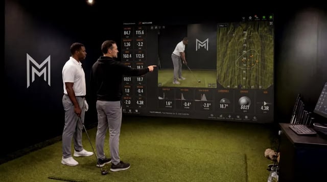 Trend-line analytics on a wall-mounted screen showing session-over-session progression.