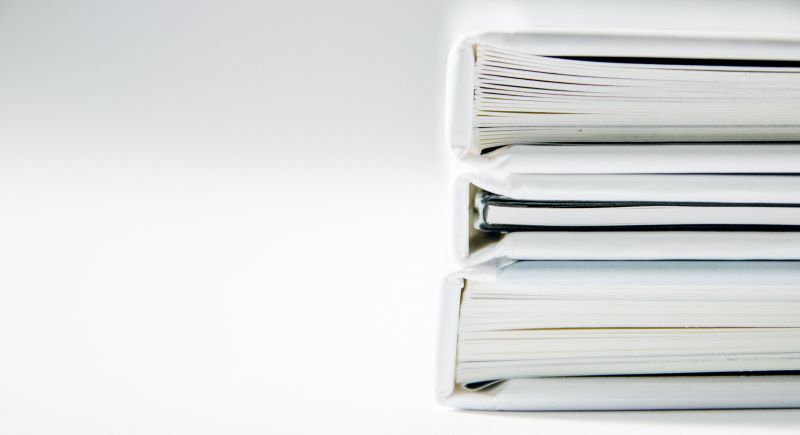 Stack of white HR policy binders