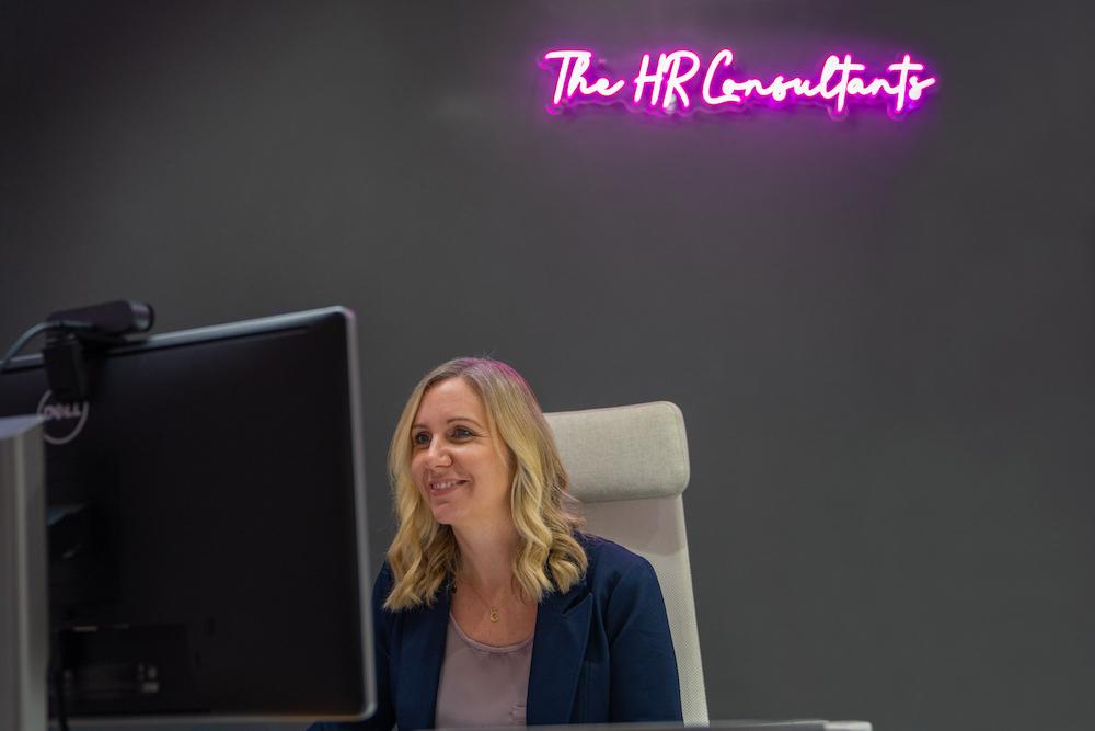 Businesswoman smiling at computer screen in modern office