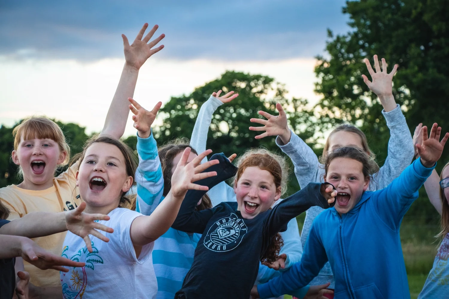 A group of pupils enjoying songs around the campfire on a school residential trip with Cairngorms Activities