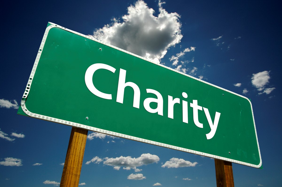 green road sign with the word charity painted