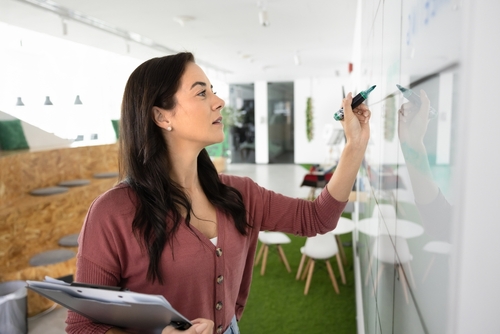 Woman writing on white board