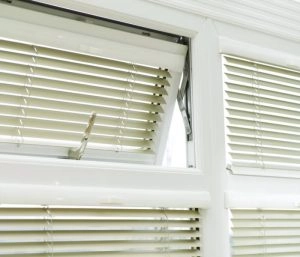 White awning window with open blinds.