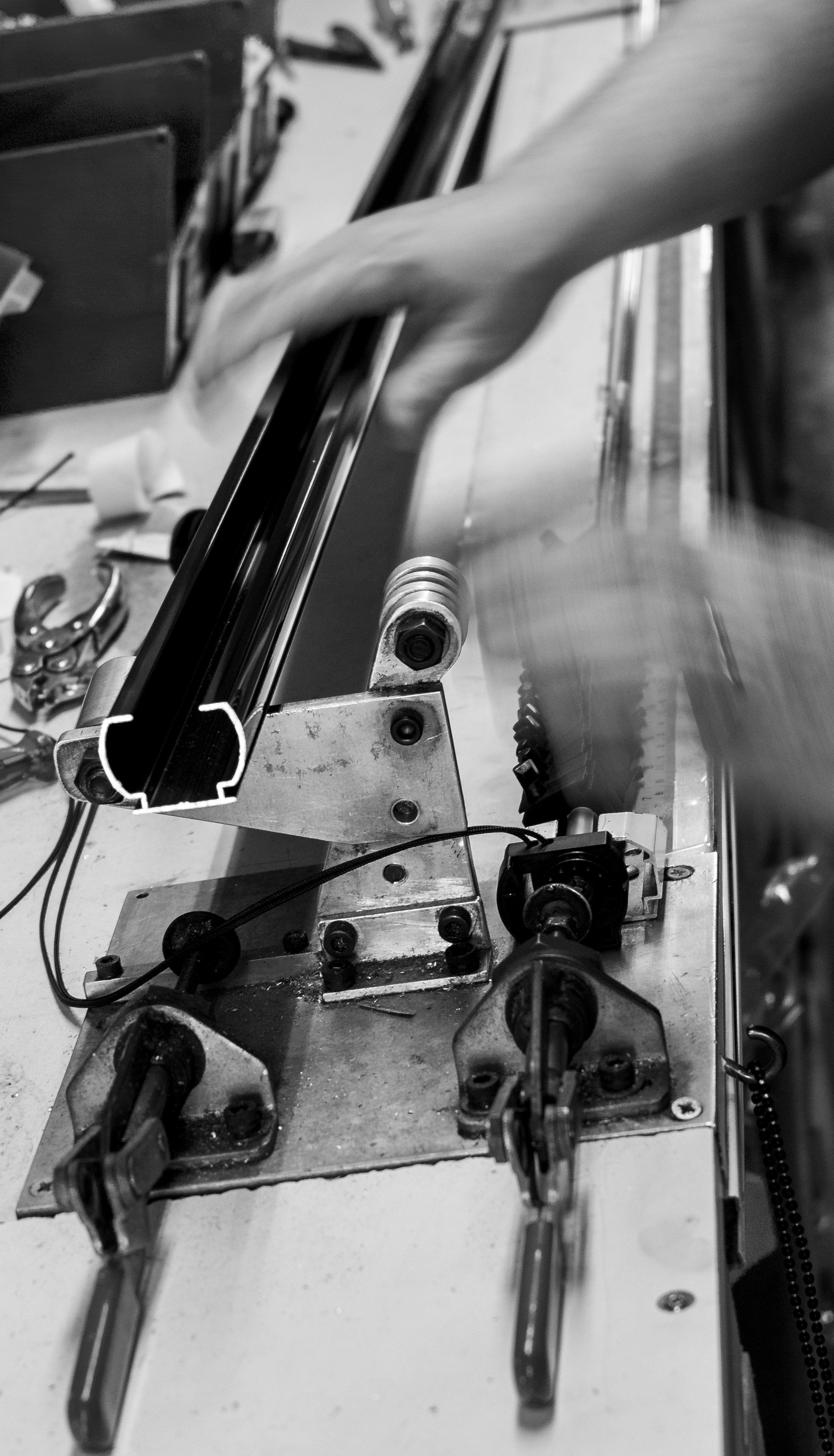 Close-up of UK-made blinds manufacturing process, showing a hand operating machinery.