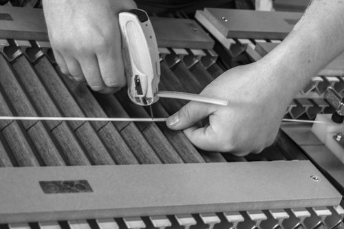 Hands securing blinds with a tool, possibly for Knowledge Centre project.
