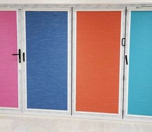 Colourful pleated blinds in pink, blue, orange, and turquoise, showcased in a case study.