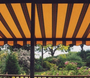 Striped yellow awning over a deck, providing shade and style.