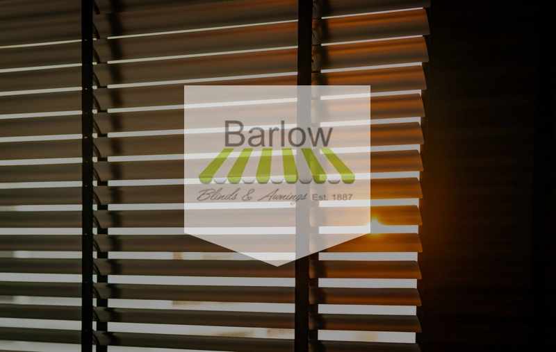 Brown window blinds with Barlow Blinds & Awnings logo superimposed. 
