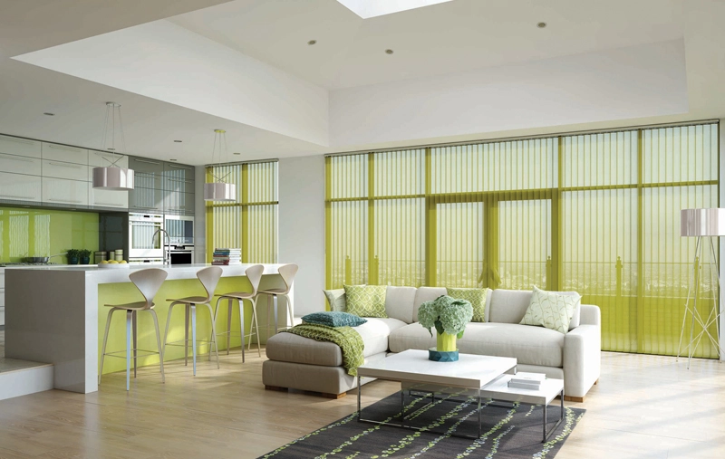 Modern open-plan living space with kitchen, seating area, and large windows with vertical blinds.