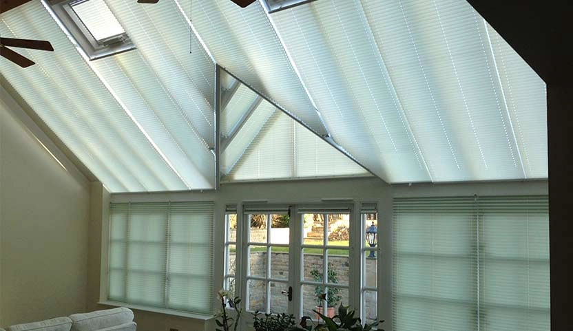 Conservatory interior with fitted blinds on the windows and roof.