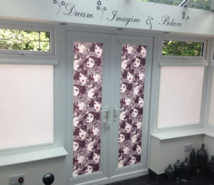 French doors with custom patterned blinds in a bright sunroom. 