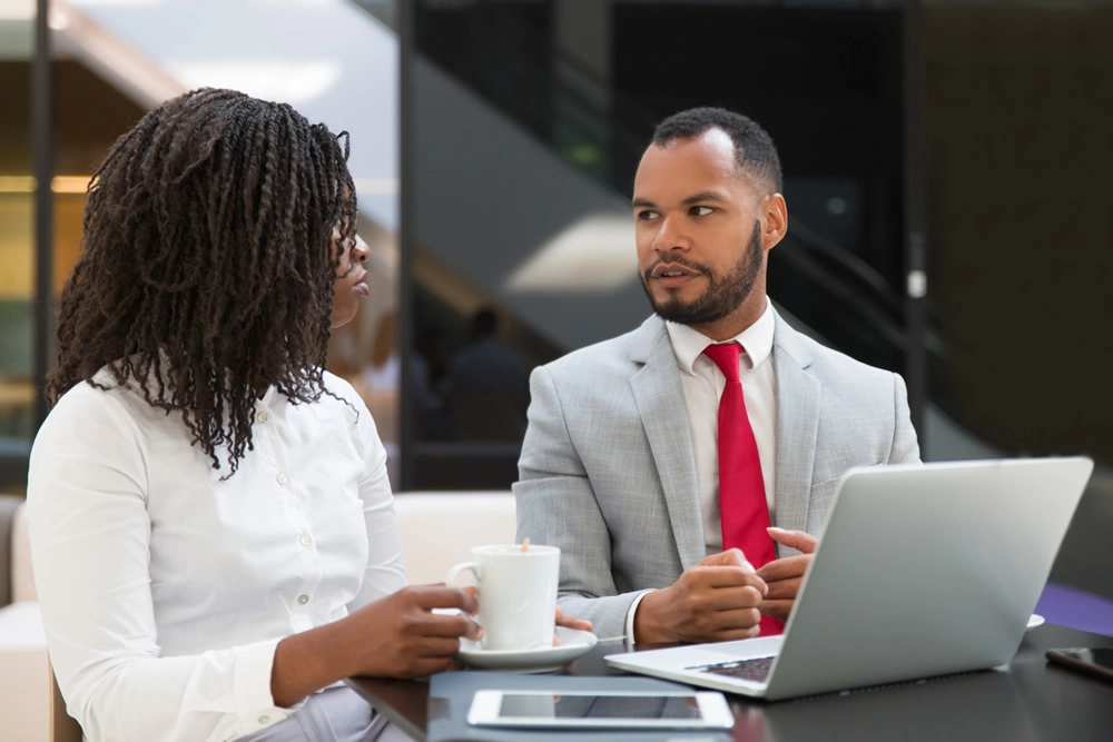 colleagues-discussing-work-at-desk