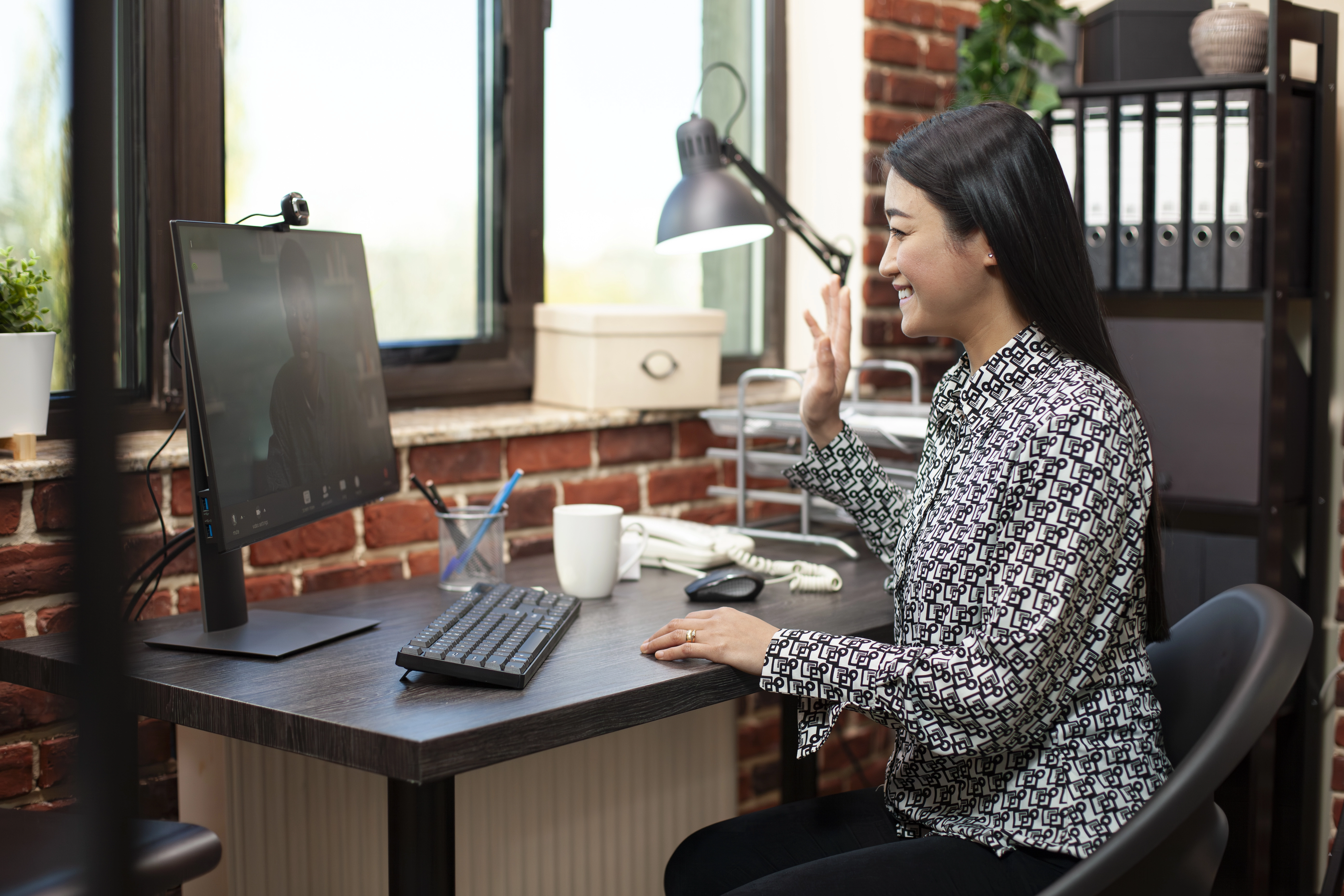 woman-waves-hello-client-videocall