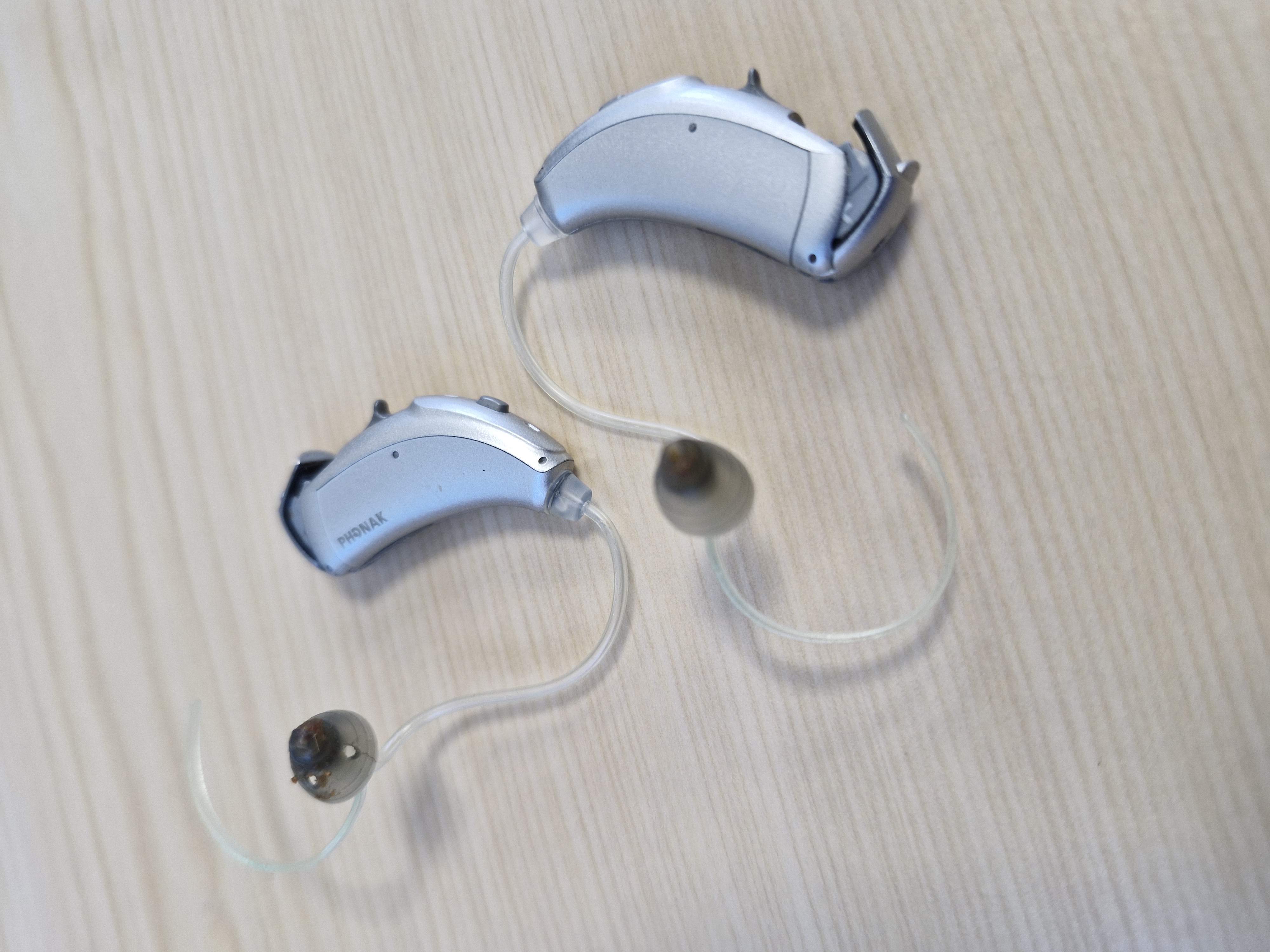  A close-up of a modern behind-the-ear hearing aid with a clean wax guard filter.