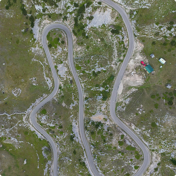 A snaking road going up a hill from a bird's eye view