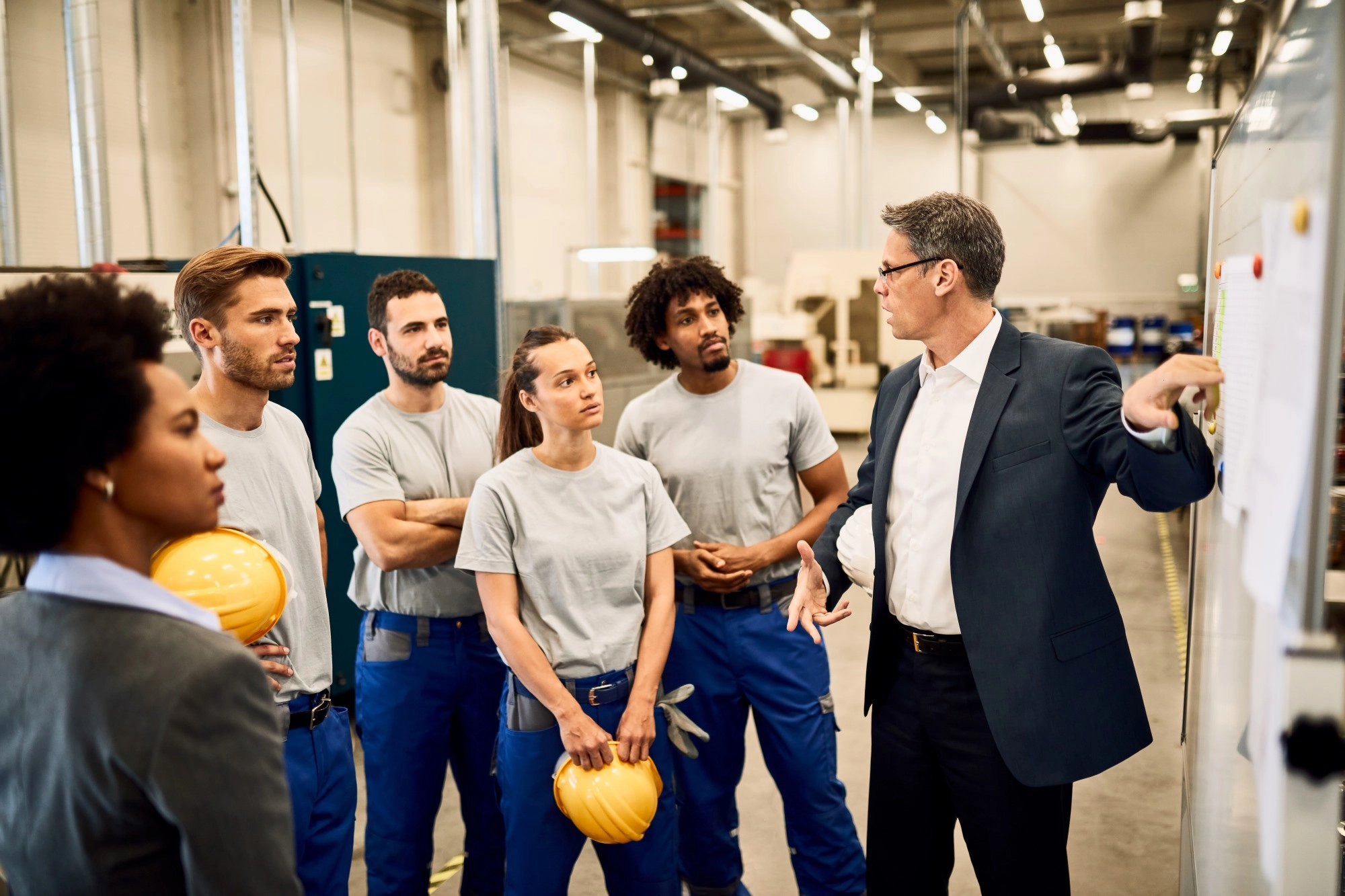 man-giving-presentation-group-industrial-workers-factory